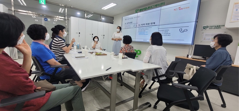 서울 성동구 성수동 소재 행복커넥트 ICT 관리센터에서 진영하 심리상담사(서있는 사람)와 현장 케어 매니저들이 회의를 하고 있는 모습. (사진=SK텔레콤 제공)