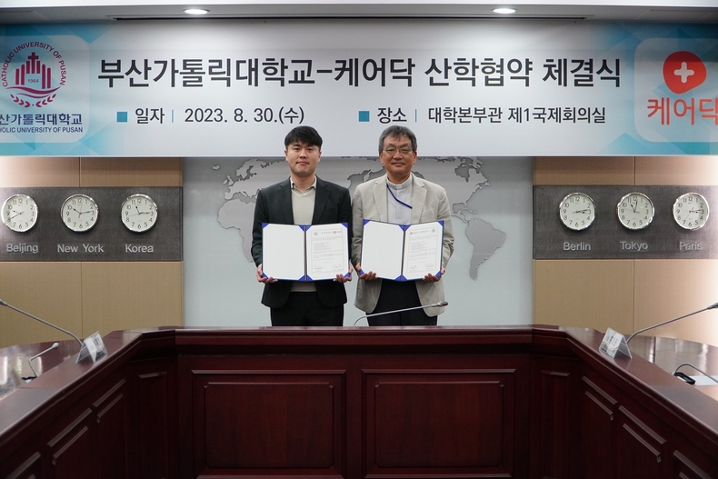 (왼쪽부터)케어닥 박재병 대표, 부산가톨릭대 홍경완 총장이 업무협약을 체결하고 기념 촬영을 하고 있다. (사진=케어닥 제공)